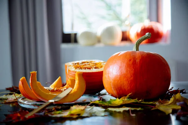 Gesneden pompoen op een bord met bestek op tafel — Stockfoto