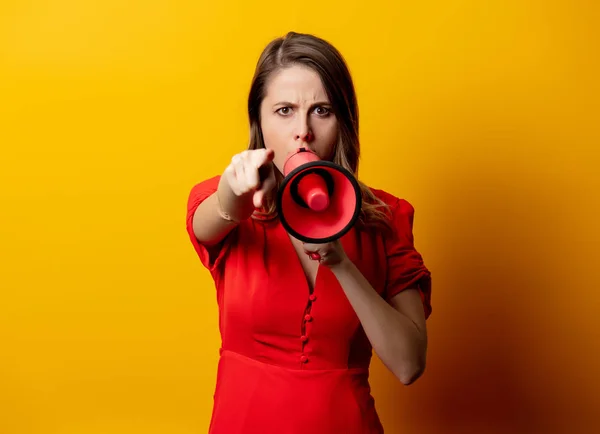 Beautiful woman in red dress with loudspeaker — Stockfoto