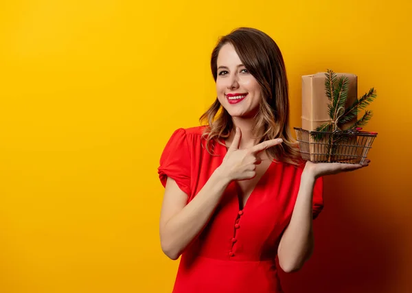 Mulher bonita com caixa de presente de Natal no fundo amarelo — Fotografia de Stock