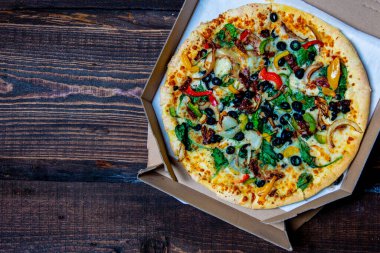 Akdeniz pizzası, zeytin ve peynirle ahşap masada.