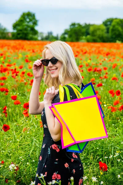 夏天的时候 穿着漂亮衣服 提着购物袋在罂粟地里的金发姑娘 — 图库照片