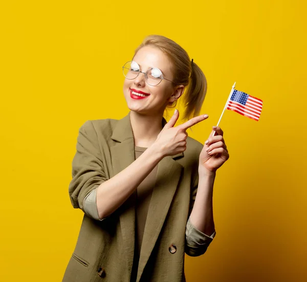 スタイルブロンド女性でジャケットで米国のフラグで黄色の背景 — ストック写真