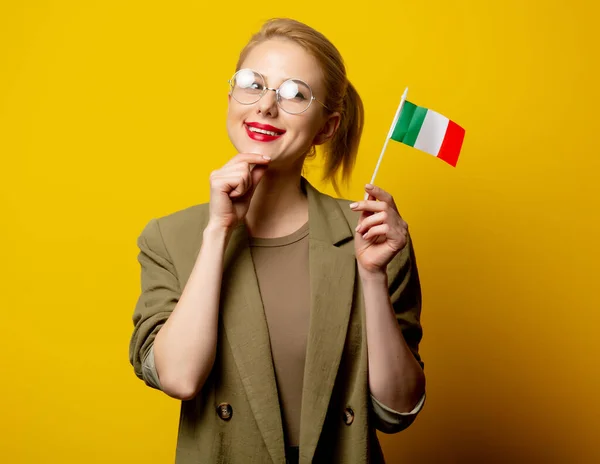 Style blonde woman in jacket with Italian flag on yellow background