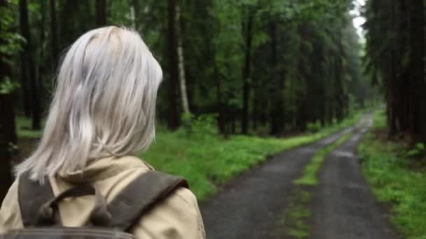 Blond Kvinna Med Ryggsäck Promenader Regnig Skog — Stockvideo