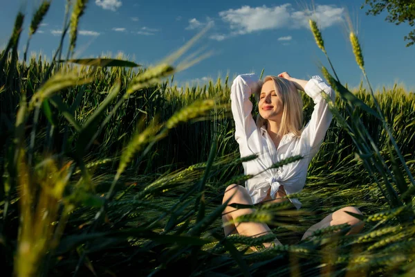 Beautiful Blonde Girl White Shirt Sits Wheat Ears Field Sunset — Stock Photo, Image