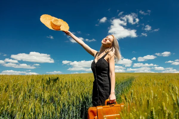 美しいですブロンド女の子とともにスーツケースで小麦畑で晴れた日 — ストック写真