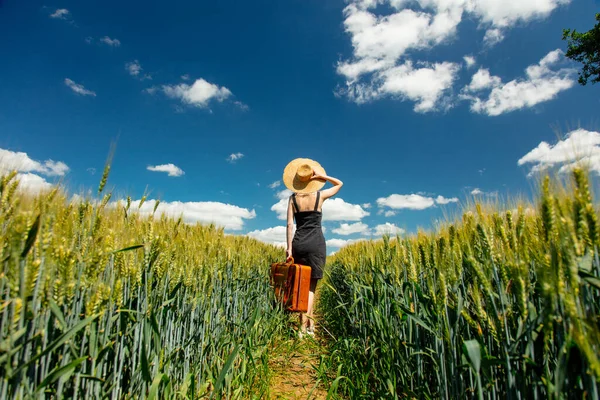 美しいですブロンド女の子とともにスーツケースで小麦畑で晴れた日 — ストック写真