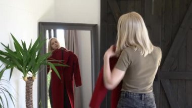 Sarışın kız, sonbahar sezonu için kırmızı bir ceket seçiyor.