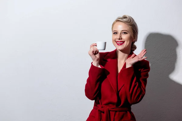 Blondýny Dívka Červeném Kabátu Retro Účes Šálkem Kávy Bílém Pozadí — Stock fotografie