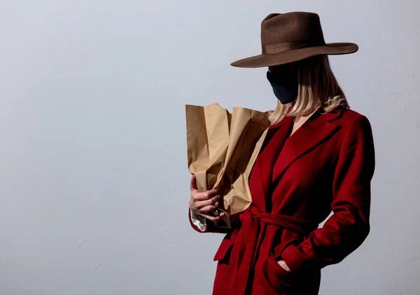 Kırmızı Ceketli Maske Takan Gri Arka Planda Kağıt Torbalı Sarışın — Stok fotoğraf