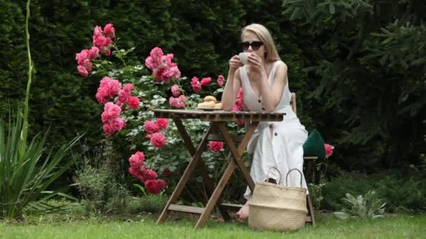 Blonde Fille Boire Café Dans Jardin Avec Des Roses — Video