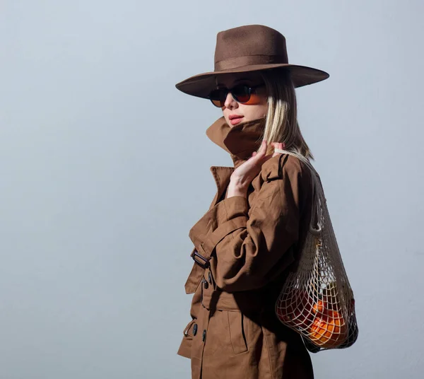 Güneş Gözlüklü Pelerinli Kadın Beyaz Arka Planda Net Çanta Tutuyor — Stok fotoğraf