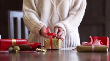 Kazaklı kadın Noel hediyesini masaya sarıyor.