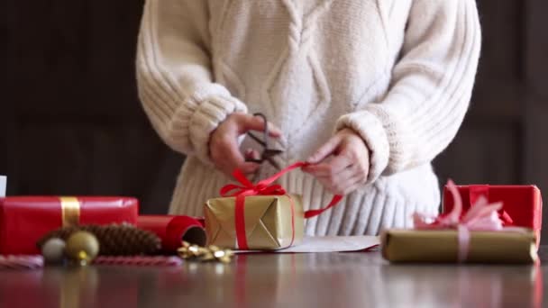 Egy Pulóveres Karácsonyi Ajándékot Csomagol Asztalra — Stock videók