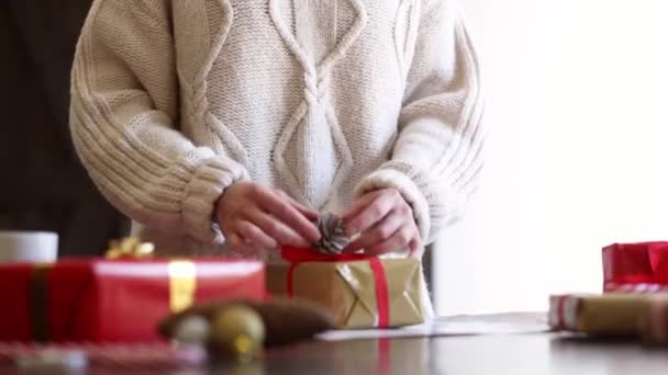 Frau Pullover Wickelt Ein Weihnachtsgeschenk Auf Einen Tisch — Stockvideo