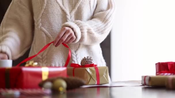 Γυναίκα Πουλόβερ Τυλίγει Ένα Χριστουγεννιάτικο Δώρο Ένα Τραπέζι — Αρχείο Βίντεο