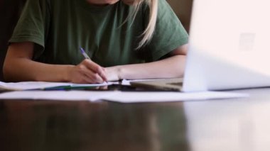 Kız evde defter ile çalışıyor. Serbest yazar olarak.