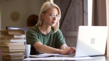 Kız evde defter ile çalışıyor. Serbest yazar olarak.