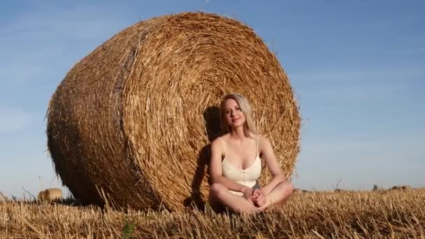 Blond Meisje Zit Door Een Opgerolde Hooiberg Het Veld Zonsondergang — Stockvideo