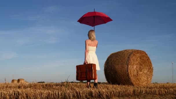 Blondýnka Dívka Kufrem Deštníkem Ubytuje Blízkosti Rolovací Kupky Sena Poli — Stock video