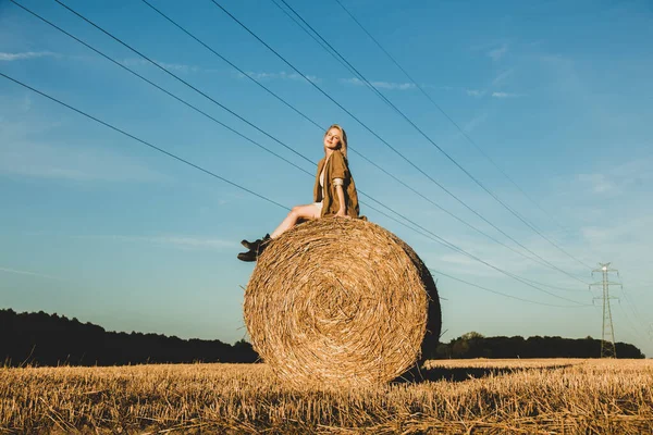 Menina Loira Está Sentada Palheiro Rolou Campo Pôr Sol Tempo — Fotografia de Stock