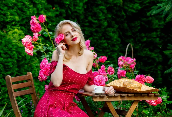 Vacker Blond Flicka Röd Klänning Dricka Kaffe Trädgård — Stockfoto