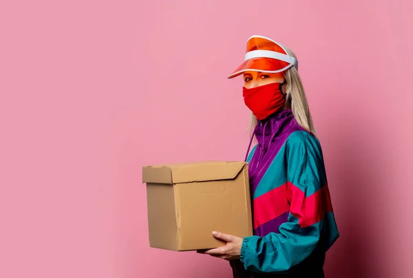 蒙面妇女和80年代衣服配带粉色背景的分娩盒 — 图库照片