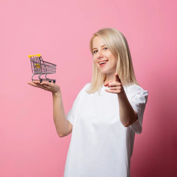 Blondýny Žena Bílém Moch Tričko Nákupním Vozíkem Růžovém Pozadí — Stock fotografie