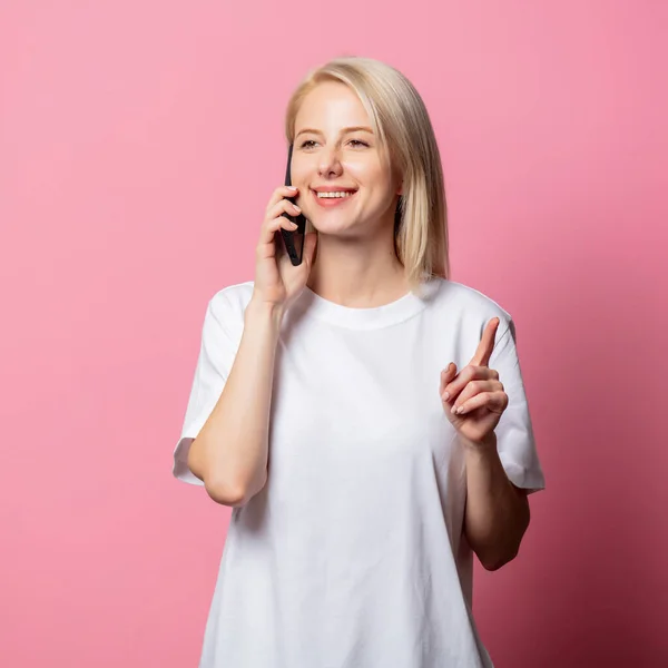 Blond Vrouw Wit Moch Tshirt Met Mobiele Telefoon Roze Achtergrond — Stockfoto