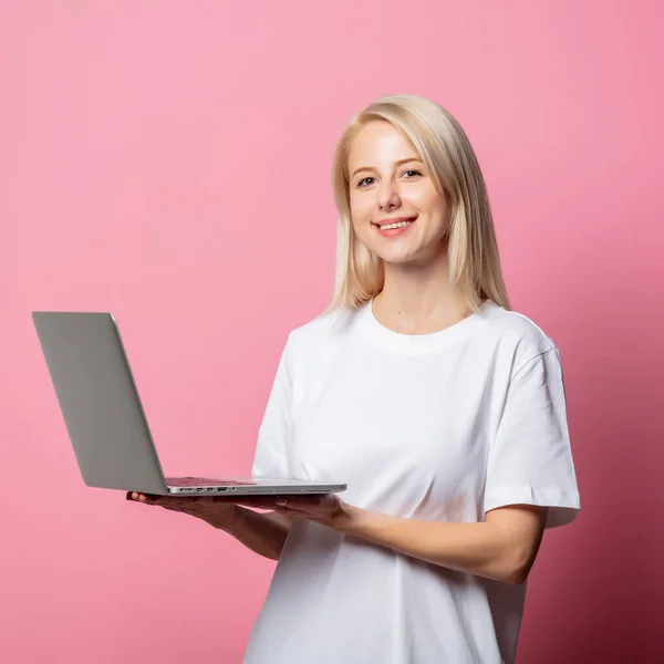 Blondynka Białej Bluzce Moch Laptopa Pieniędzmi Różowym Tle — Zdjęcie stockowe