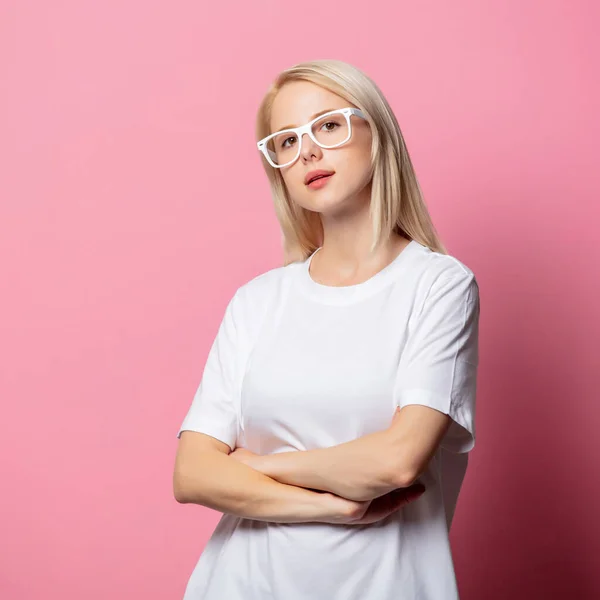 Beyaz Tişörtlü Pembe Arka Planda Gözlüklü Sarışın Kadın — Stok fotoğraf