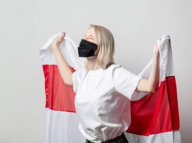 Beyaz arka planda ulusal Beyaz Rusya bayrağı olan maskeli kadın.
