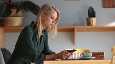 Kız telefonda konuşuyor ve kafede kahve içiyor.