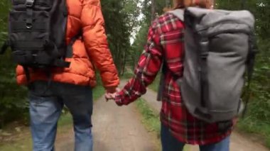Genç çift dağlarda ormanda yürüyor.