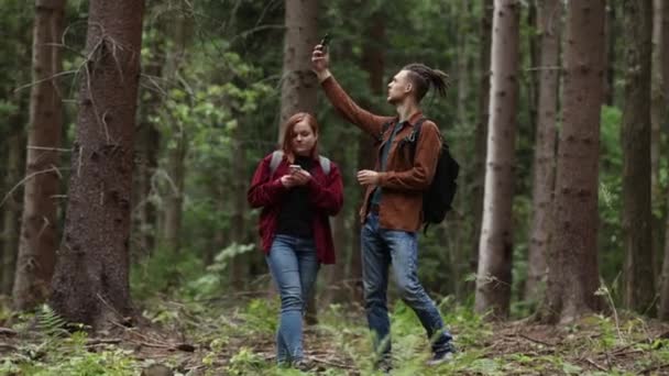 这对年轻夫妇正在森林里寻找一个流动电话 — 图库视频影像
