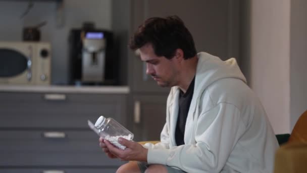 感冒的人坐在沙发上吃药 — 图库视频影像