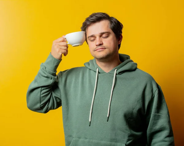 Cara Com Capuz Verde Com Xícara Café Fundo Amarelo — Fotografia de Stock