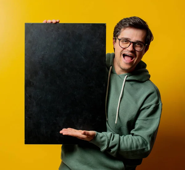 Chico Con Capucha Verde Con Pizarra Sobre Fondo Amarillo — Foto de Stock