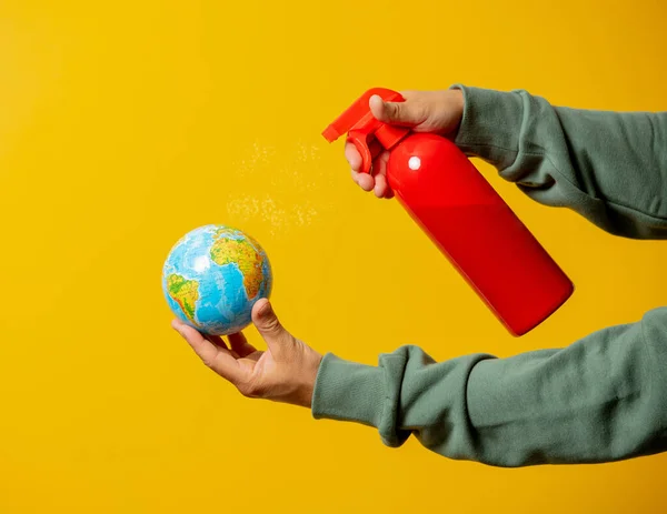 Mann Sprüht Desinfektionsmittel Auf Erde Globus Auf Gelbem Hintergrund — Stockfoto