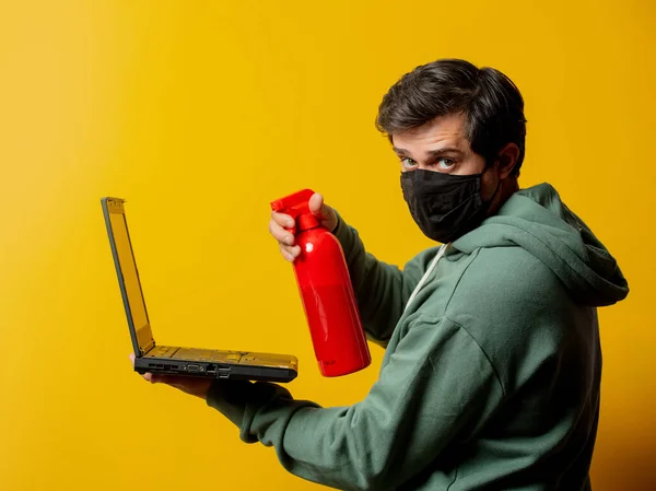 Mann Gesichtsmaske Hält Desinfektionsspray Und Notizbuch Auf Gelbem Hintergrund — Stockfoto