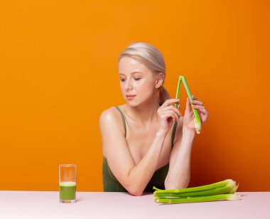 Mayolu şık sarışın kereviz suyunun yanında oturuyor.