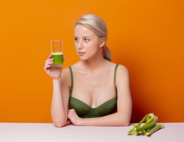 Mayolu şık sarışın kereviz suyunun yanında oturuyor.