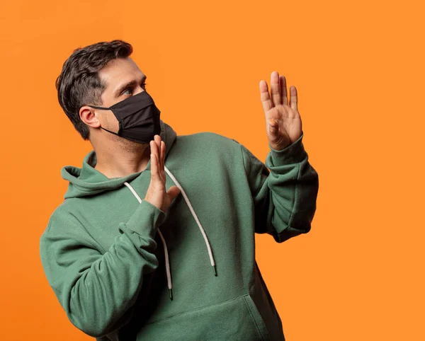 Chico Máscara Facial Sudadera Con Capucha Verde Sobre Fondo Naranja —  Fotos de Stock