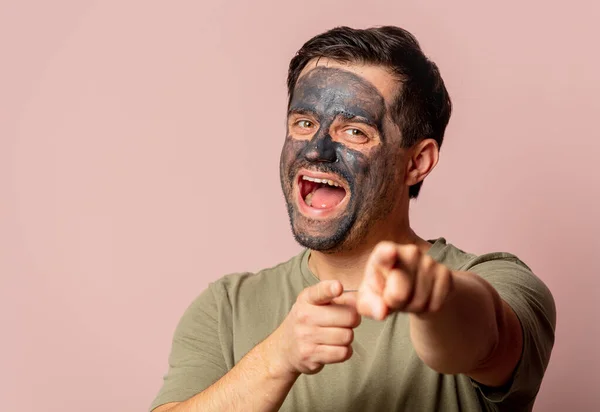 Grappig Guy Met Een Cosmetische Masker Zijn Gezicht Roze Achtergrond — Stockfoto