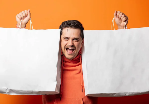 Lachende Man Oranje Hoodie Met Boodschappentassen Een Oranje Achtergrond — Stockfoto