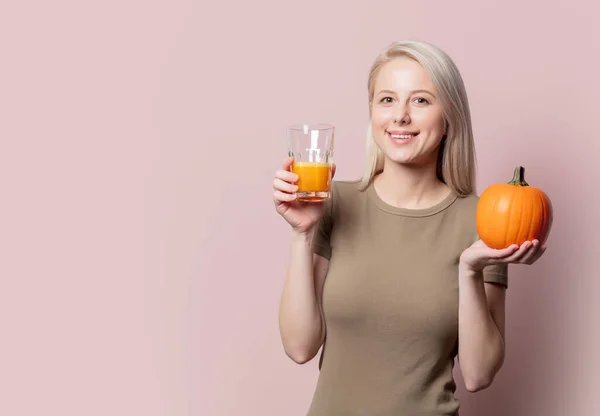 Blonde Frau Mit Kürbissaft Auf Rosa Hintergrund — Stockfoto