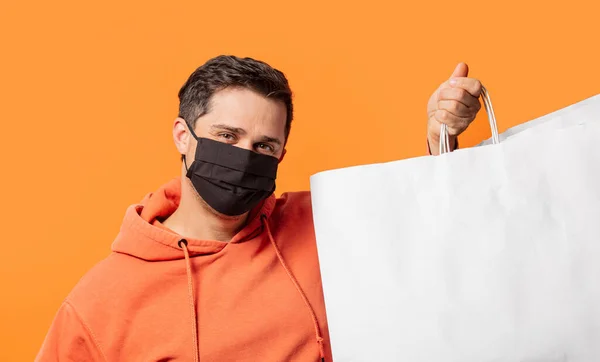 Cara Máscara Facial Com Sacos Compras Fundo Laranja — Fotografia de Stock