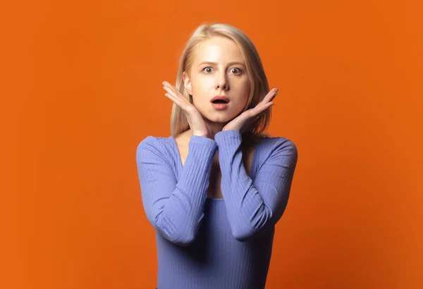 Rubia Sorprendida Blusa Azul Sobre Exuberante Fondo Color Naranja —  Fotos de Stock