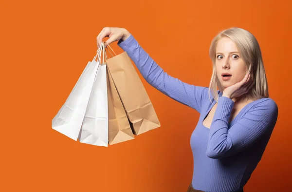 Överraskad Blond Blå Blus Med Shoppingväskor Sprudlande Orange Färg Bakgrund — Stockfoto