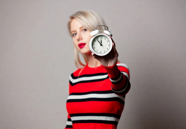 スタイル女の子で赤いセーターとともに目覚まし時計上の灰色の背景 — ストック写真